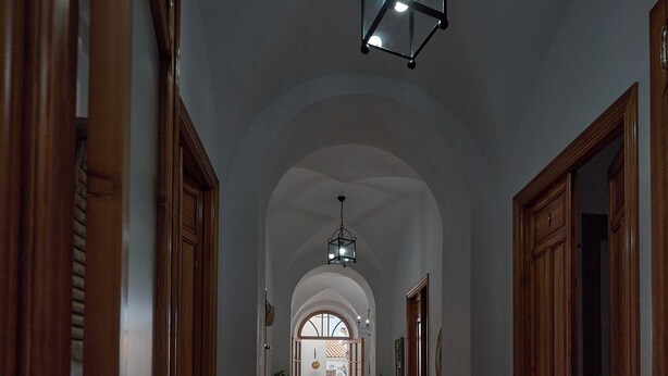 A hallway with wooden doors, a tiled floor with floral patterns, and a hanging light fixture. - El Viejo Olivo Country House - Valencia del Ventoso (Valencia del Ventoso)