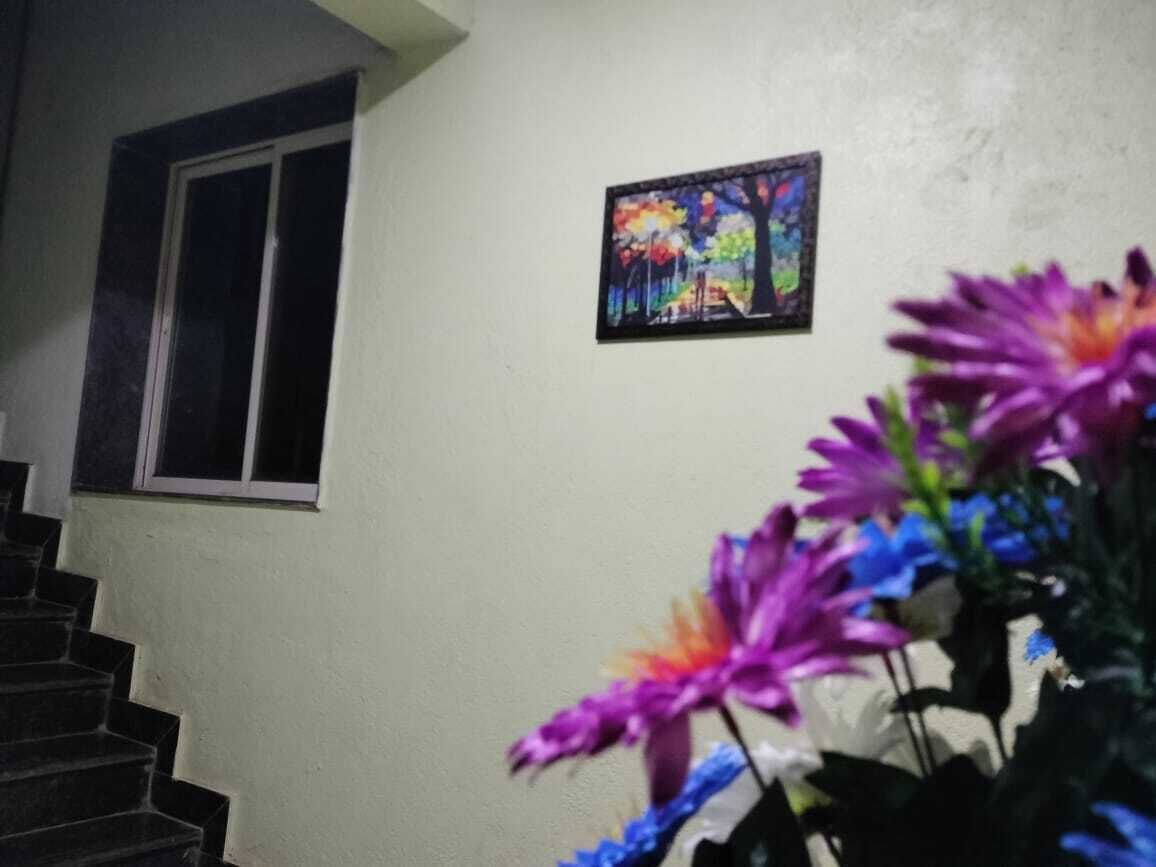 A staircase leading to a room with a window and a painting on the wall.