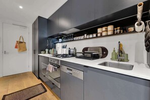 Une cuisine moderne équipée d’un four encastré, d’un lave-vaisselle et d’un évier.