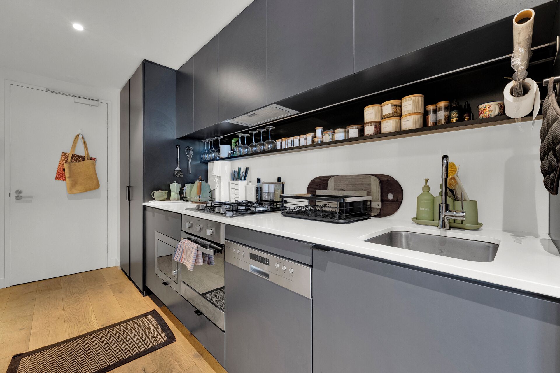 A modern kitchen with a built-in dishwasher, a stove, and a sink.