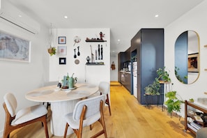 Une cuisine moderne avec une table de salle à manger ronde, des chaises et divers appareils de cuisine.