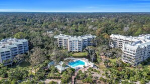 A resort with multiple buildings, a central swimming pool, and surrounding greenery. - Oceanfront beach villa in Palmetto Dunes (Hilton Head Island)