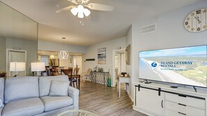 A living room with a sofa, coffee table, TV, and a ceiling fan. - Oceanfront beach villa in Palmetto Dunes (Hilton Head Island)