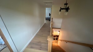 A staircase with wooden steps and a light fixture on the wall. - On Wyman Pond. Home on sprawling property with a pond, hiking & wildlife. (Sidney Center)
