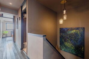 A hallway with a modern design, including a light fixture and a painting on the wall. - Gorgeously Designed 2BD Flat, Heart of East London (Greater London)