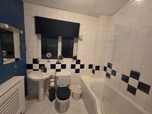 A bathroom with a toilet, bidet, sink, and bathtub.
