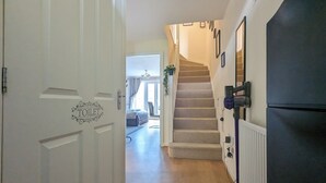A hallway with a white door marked "TOILET," a staircase, and a black refrigerator. - This is a large three-story house, located near the city centre. A short 4-minute drive (1 mile) will take you to the city centre, Albert Dock, ACC. Convenient public transportation is available with a 10-minute bus ride from the city. centre. (Merseyside)