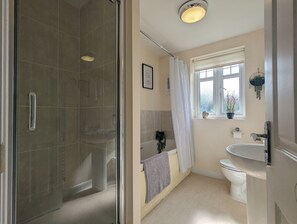 Une salle de bain avec une douche à parois de verre, une baignoire, des toilettes et un lavabo.