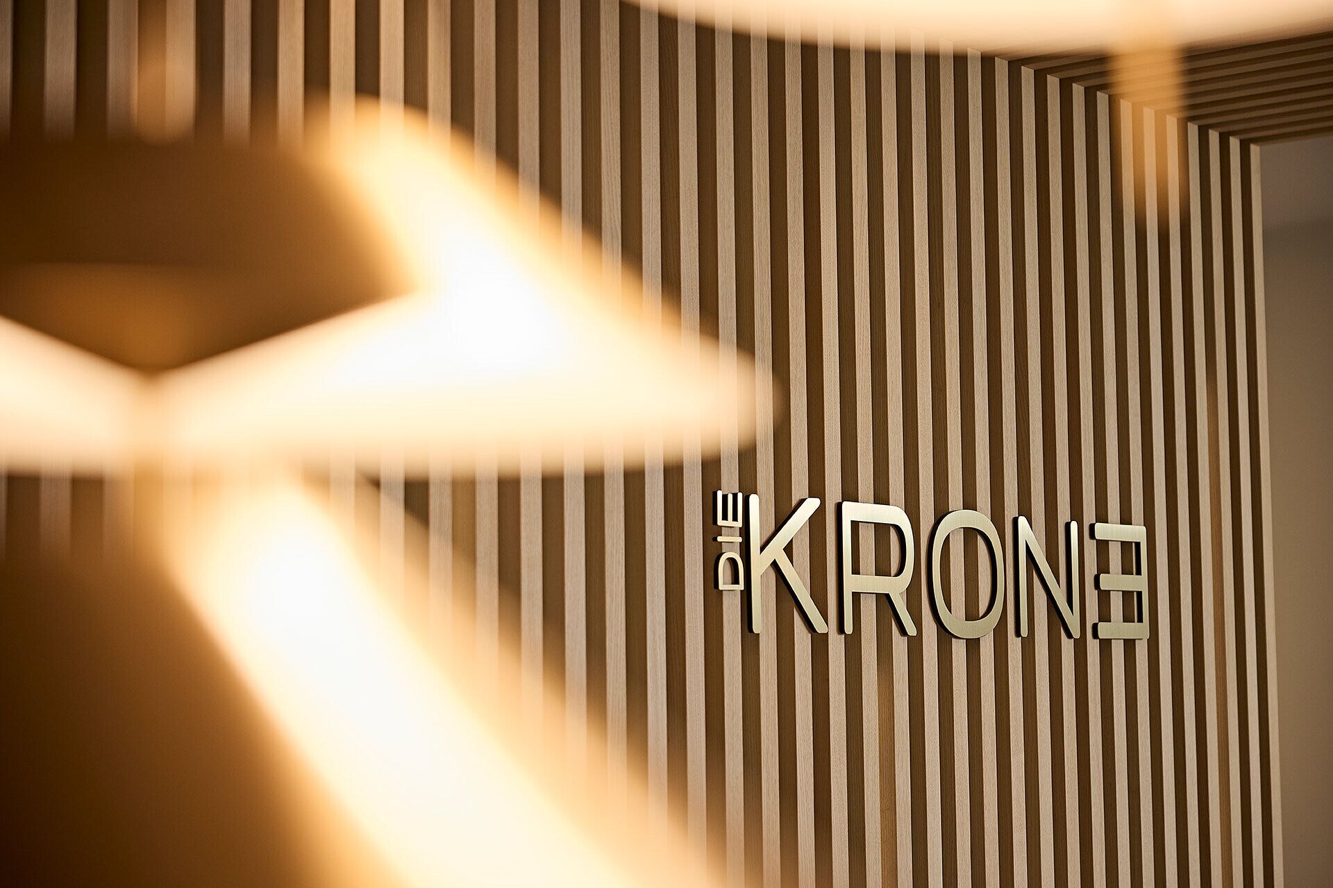 A wall with vertical wooden slats and the text 'THE KRONE' in a metallic font.
