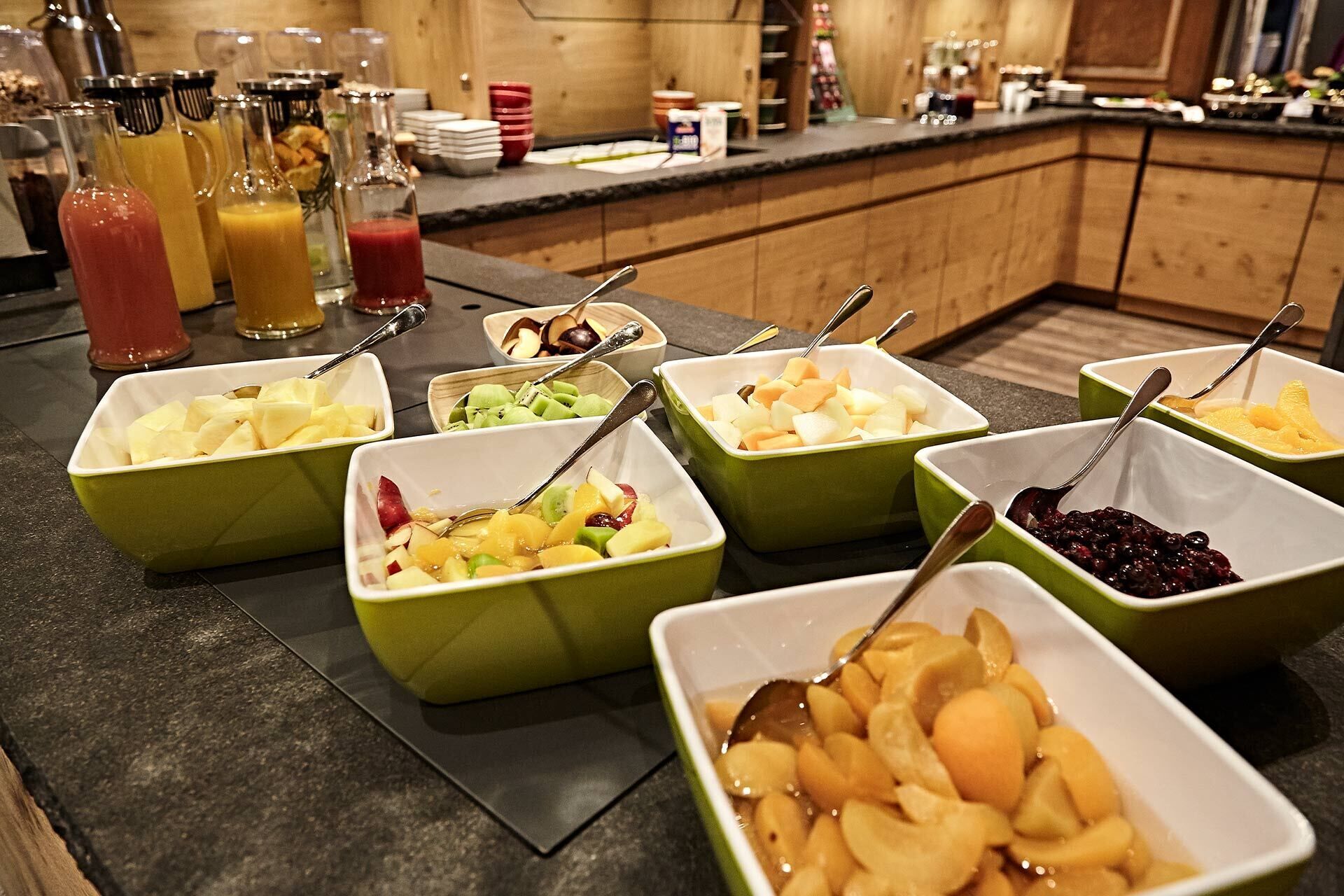 Un bufé con diversas frutas y bebidas.