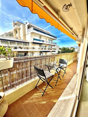 A balcony with a view of a multi-story building, outdoor furniture, and a decorative railing. - Very nice apartment in carré d'or - 3* - City center and beaches (Antibes)