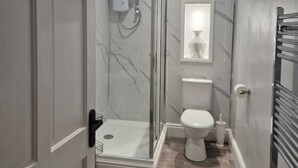 Une salle de bain équipée d’une douche, de toilettes et d’une indication signalant la pièce.