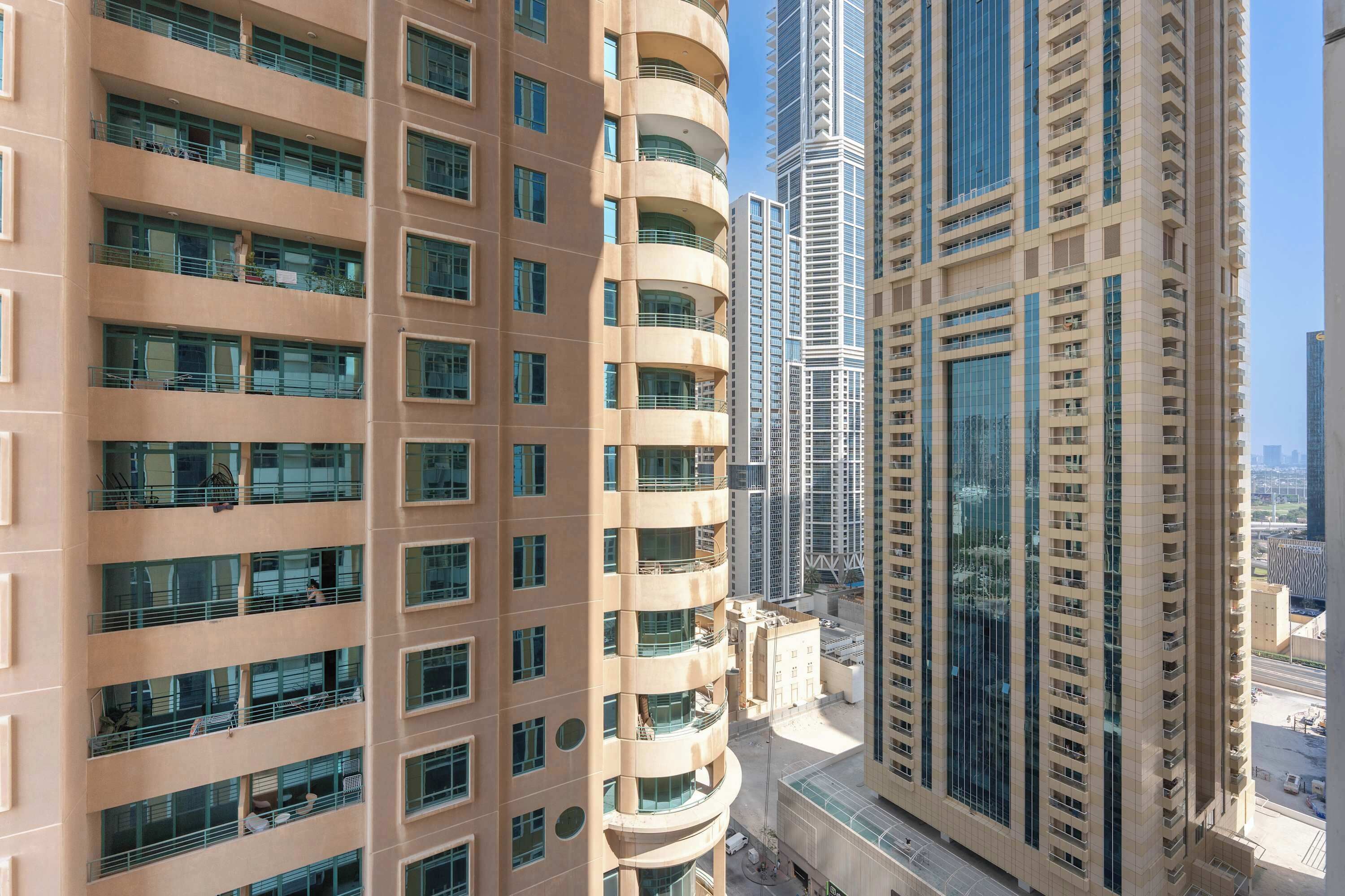 A high-rise building with multiple balconies and large windows.