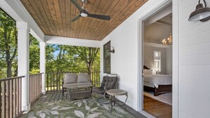 A covered porch with a wooden ceiling, a green patterned rug, a sofa, a chair, and a small table. - Walkable Hillsboro Home - Near 12 South & Vandy (Nashville)