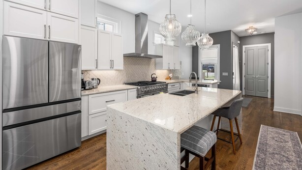 A modern kitchen with stainless steel appliances, a marble island, and pendant lighting. - Walkable Hillsboro Home - Near 12 South & Vandy (Nashville)