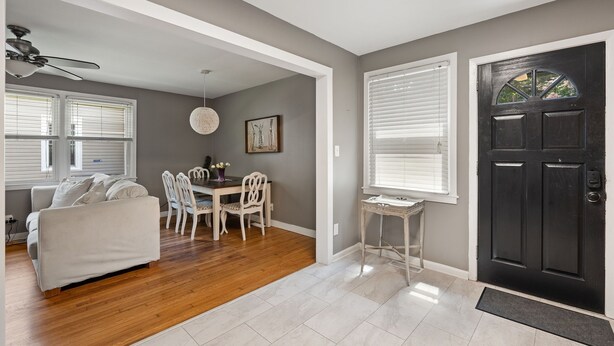 A living room with a sofa, dining table, chairs, and a ceiling fan. - Home near DTWS, UNCAS, WFU, Hospitals, food/bev! (Winston-Salem)