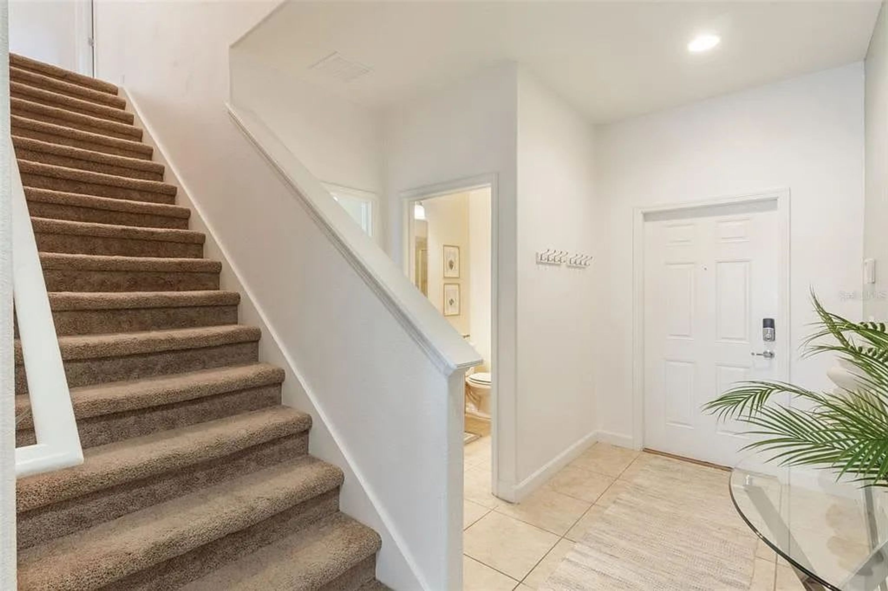 A staircase with carpeted steps leading to a white door.