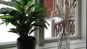 A window with a potted plant and a vase with dried plants. - Porter House Tingshus (Hammarstrand)