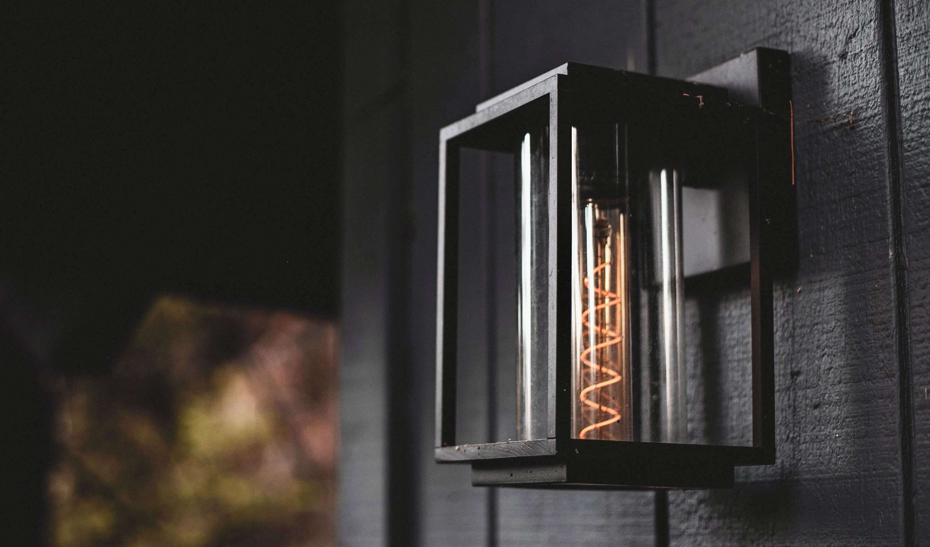 Uma luminária de parede com lâmpada de filamento aparente.