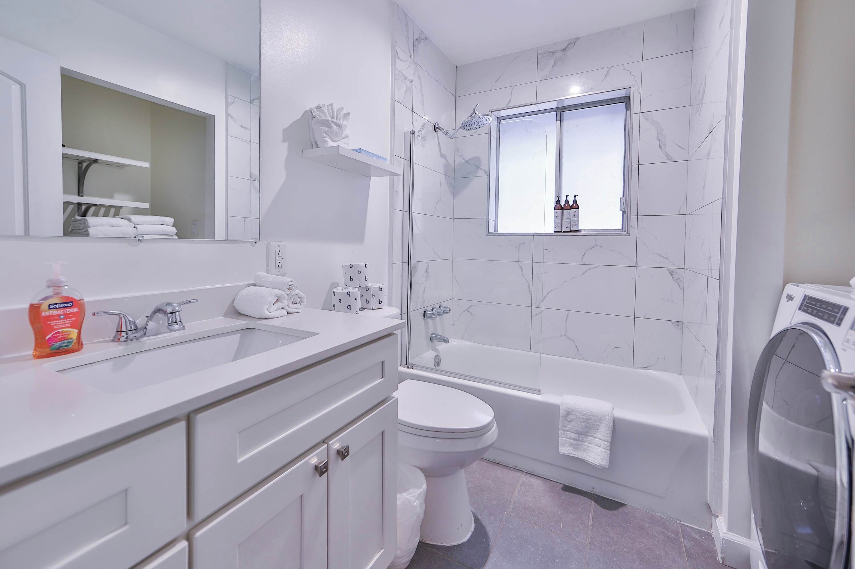 Une salle de bain moderne avec un double vasque, des toilettes et une baignoire.