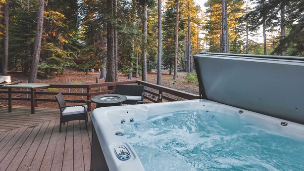 A hot tub on a wooden deck surrounded by trees. - Iroquois Ridge Charming Home for 8 w/ Hot Tub Near Lake Tahoe & Skiing (South Lake Tahoe)