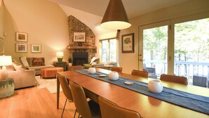 Un comedor con una larga mesa de madera, sillas y una chimenea en el centro.