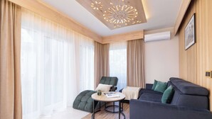 A modern living room with a sofa, a round table, and a chair. - Spacious Apartment in Zakopane | Terrace with a View, Sauna, Parking (Zakopane)