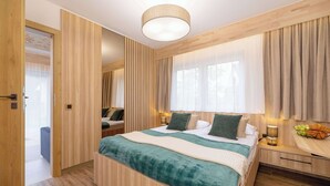 A modern bedroom with a wooden bed, bedside tables, and a large window with curtains. - Spacious Apartment in Zakopane | Terrace with a View, Sauna, Parking (Zakopane)