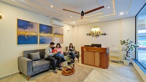 Ein moderner Empfangsbereich mit einer Couch, einem Empfangstresen und Kunstwerken an den Wänden.