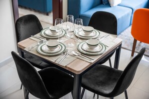 A dining table set with plates, glasses, and cutlery. - Stayshort - Business Bay for 4 People With a Fabulous Pool (Dubai)