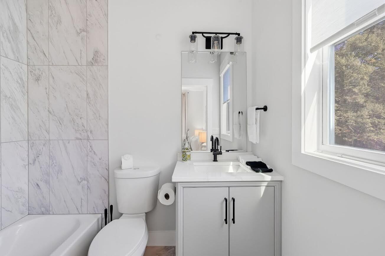 A modern bathroom with a toilet, sink, and bathtub.
