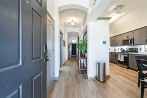 Een moderne keuken met roestvrijstalen apparatuur, een houten vloer en een centraal keukenblok.