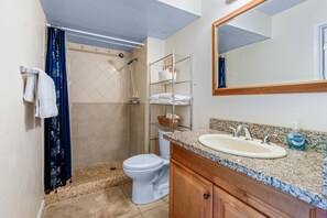 A bathroom with a shower, toilet, sink, and a mirror. - Big Island Paniolo Club 114 2 Bedroom Condo (Waikoloa)