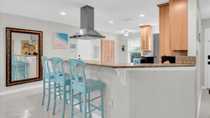 Une cuisine moderne dotée d’un îlot central, de meubles en bois et d’un grand miroir.