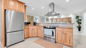 Une cuisine moderne avec des meubles en bois, des appareils électroménagers en acier inoxydable et un îlot central.
