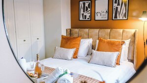 A hotel room with a bed, pillows, a bottle, glasses, and towels. - Stunning Riverside Home in Chester with Parking! (Chester)