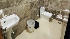 Une salle de bain avec un lavabo, des toilettes et une douche.