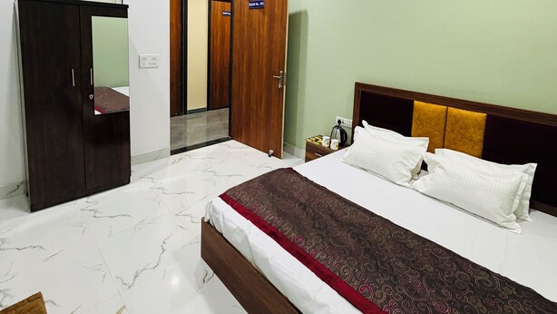 Une chambre d’hôtel avec un lit, un ventilateur de plafond, une armoire et une porte.