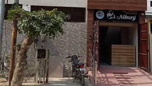 Un bâtiment à deux étages, avec une enseigne indiquant « Nikunj » au rez-de-chaussée.