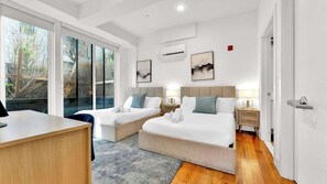 Une chambre d’hôtel avec deux lits, un bureau et une grande fenêtre.