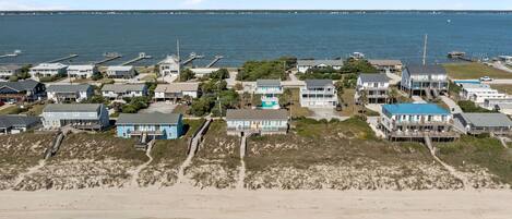 A coastal residential area with houses, a beach, and a view of the ocean.