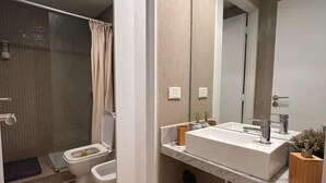 Un baño moderno con ducha, inodoro y lavamanos.