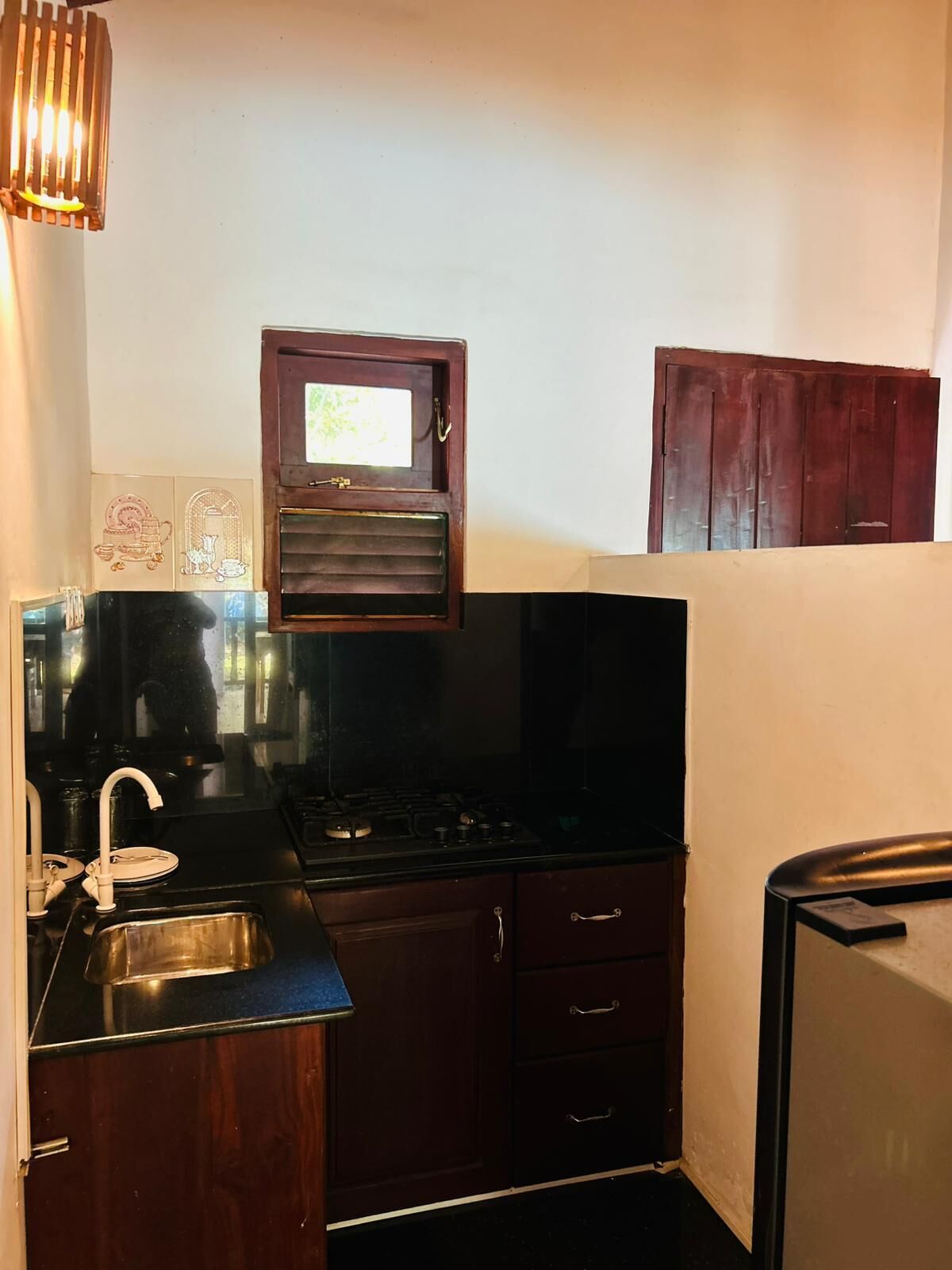 A compact kitchen with a sink, stove, and cabinets.