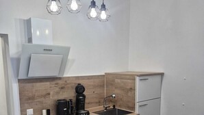 Une cuisine moderne dotée d’un plan de travail en bois, d’un four encastré, d’une machine à café et d’un évier.