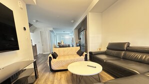 Un salon moderne avec un canapé, une table basse et un téléviseur.