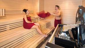 A sauna room with wooden benches, a massage table, and a steam generator. - Becci`s Apartment- Free Parking (Kapfenberg)