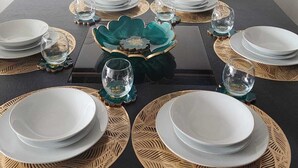 A dining table set with plates, glasses, and a decorative centerpiece.