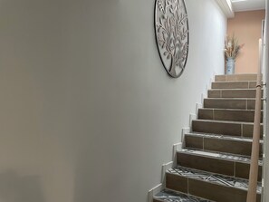 A staircase with patterned tiles and a decorative wall piece.