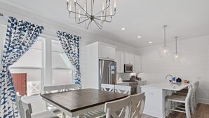 A modern kitchen with white cabinetry, a central island with seating, and pendant lighting. - 🏖️Luxury 6BR-Private Pool-Scattered, Smothered, & Covered🏖️ (Miramar Beach)