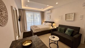 Una moderna camera d'hotel con un letto, un divano, un tavolino e un elemento decorativo a parete.